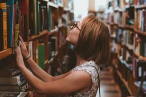 woman looking at books in library