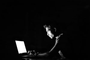 man using laptop in the dark