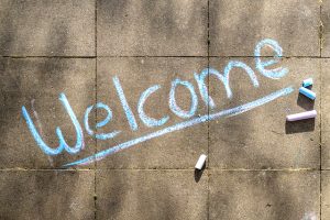 the word "welcome" written in chalk on a sidewalk