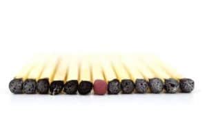 black match heads with a single red match head among them