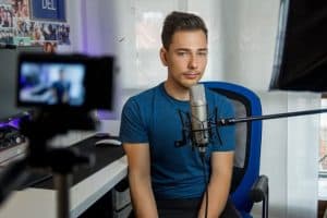 man in front of microphone and webcam