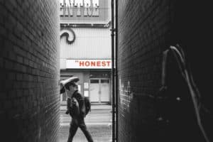 man walking on the street with the word "honest" in the background