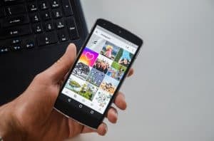 hand holding a smartphone with Instagram feed displayed