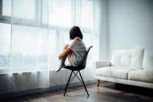 woman sitting in chair in the living room looking out the window