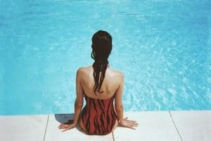 woman sitting beside a pool