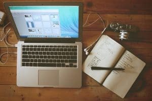 macbook beside a notebook and camera